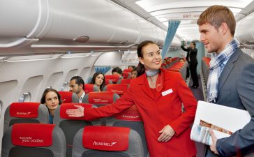 1200px-Austrian_Airlines_flight_attendant_and_passenger