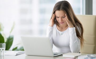 cropped-Stressed-woman-at-computer-suffering-from-a-tension-headache.jpg
