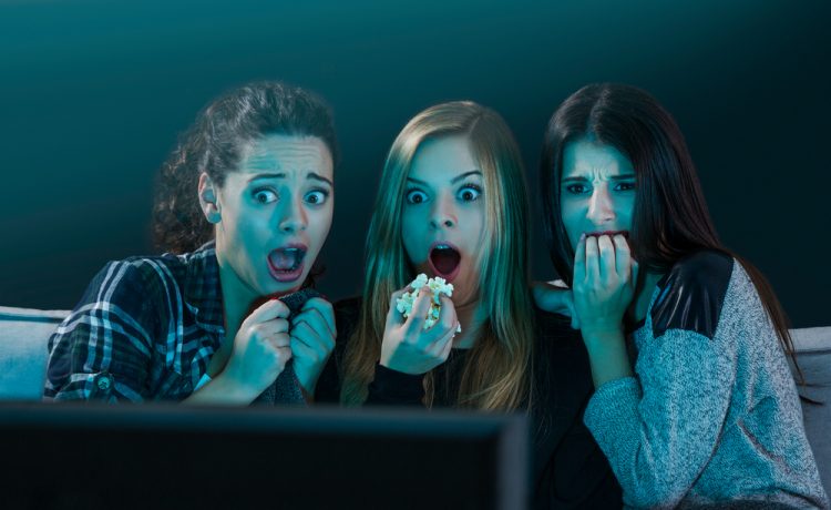 Teenage-girls-watching-horror-movie-with-popcorn-ImageikoS