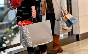 Shoppers clutch their Nordstrom bags at an Old Navy store as holiday shopping accelerates at the King of Prussia Mall