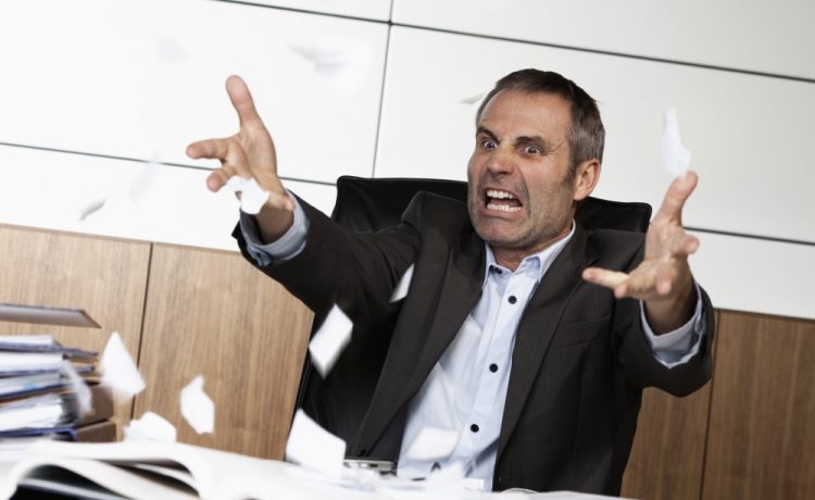 Overloaded senior businessman being upset about work, tearing pa