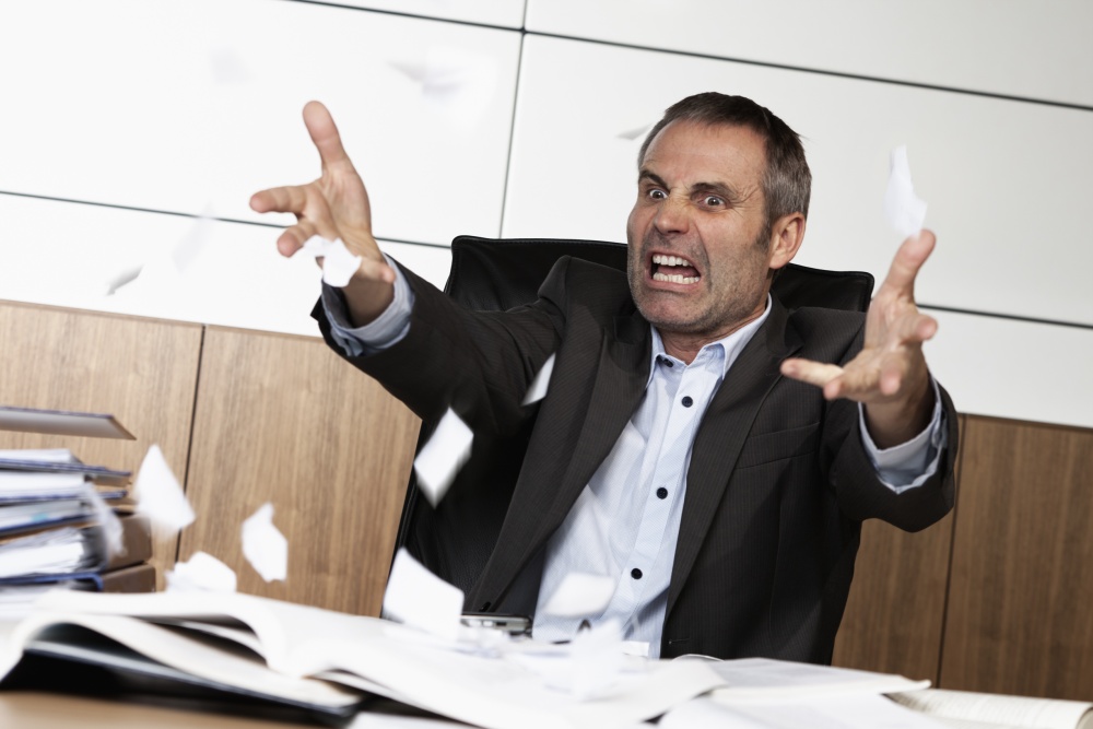 Overloaded senior businessman being upset about work, tearing pa