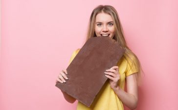 Woman with eats chocolate smiling